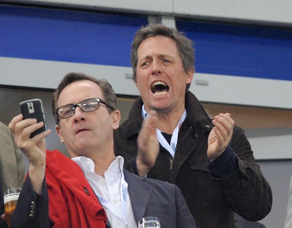 epa02154350 British actor and Fulham supporter Hugh Grant (R) cheers for his team during the UEFA Europa League final match between FC Fulham and Atletico Madrid at Hamburg Arena in Hamburg, Germany,  ...
