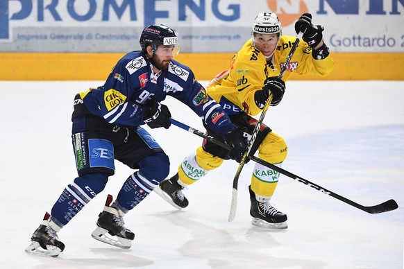 Ambri&#039;s Adrien Lauper, left, fights for the puck with Bern&#039;s player Jeremie Kamerzin, right, during the preliminary round game of National League A (NLA) Swiss Championship 2016/17 between H ...