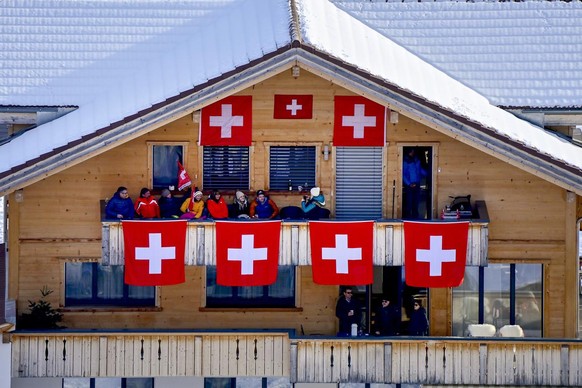 Spectators in a chalet decorated with swiss flags during the first run of the men&#039;s giant slalom race at the FIS Alpine Skiing World Cup in Adelboden, Switzerland, Saturday, January 9, 2021. (KEY ...