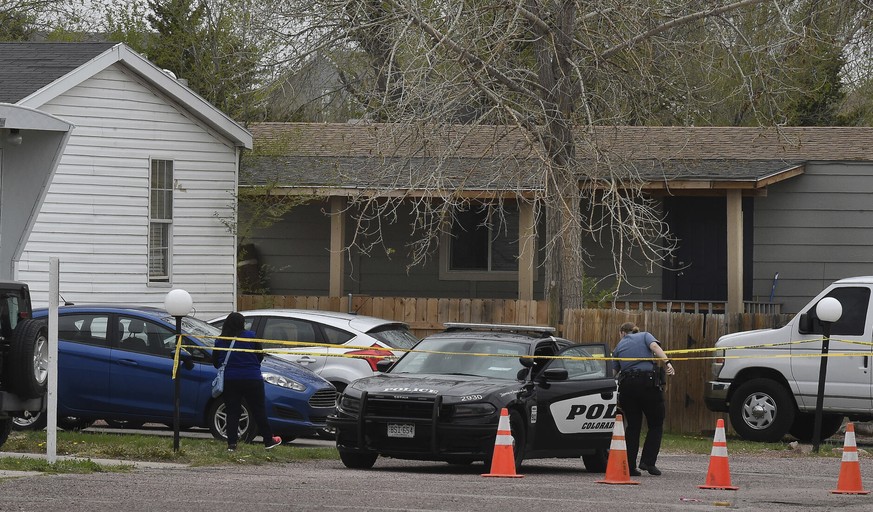 A Colorado Springs police officer goes to help a person who was in a different mobile home to be able to get to her car from behind the crime tape in Colorado Springs, Colo., Sunday, May 9, 2021. A gu ...