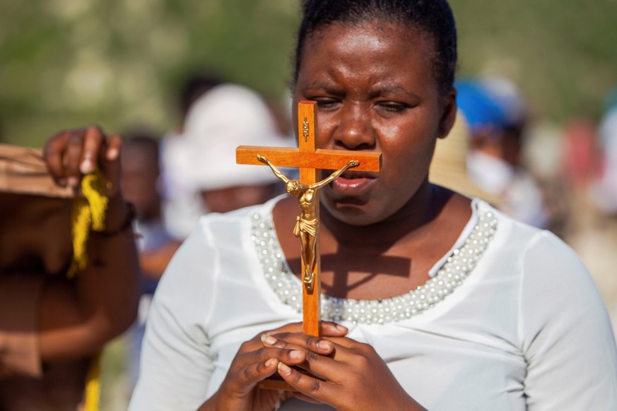 epa09112719 A woman participates in a pilgrimage during the commemoration of Good Friday, through the mountains of Port-au-Prince, Haiti, 02 April 2021. Hundreds of members of Haitian Catholic and Voo ...
