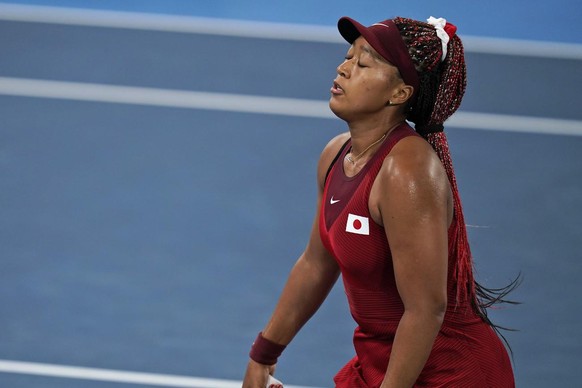 Naomi Osaka, of Japan, reacts after losing a point to Marketa Vondrousova, of the Czech Republic, during the third round of the tennis competition at the 2020 Summer Olympics, Tuesday, July 27, 2021,  ...