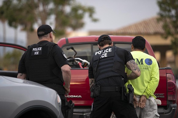 FILE - In this July 8, 2019, file photo, U.S. Immigration and Customs Enforcement (ICE) officers detain a man during an operation in Escondido, Calif. During the Trump administration&#039;s final week ...