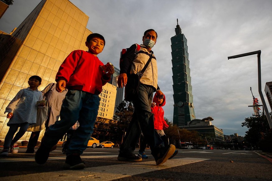 epa09031361 People cross a street in Taipei, Taiwan, 23 February 2021. Taiwan revises economic growth forecast for 2021 to expand by 4.64 percent from its early prediction of 3.83 percent last Novembe ...