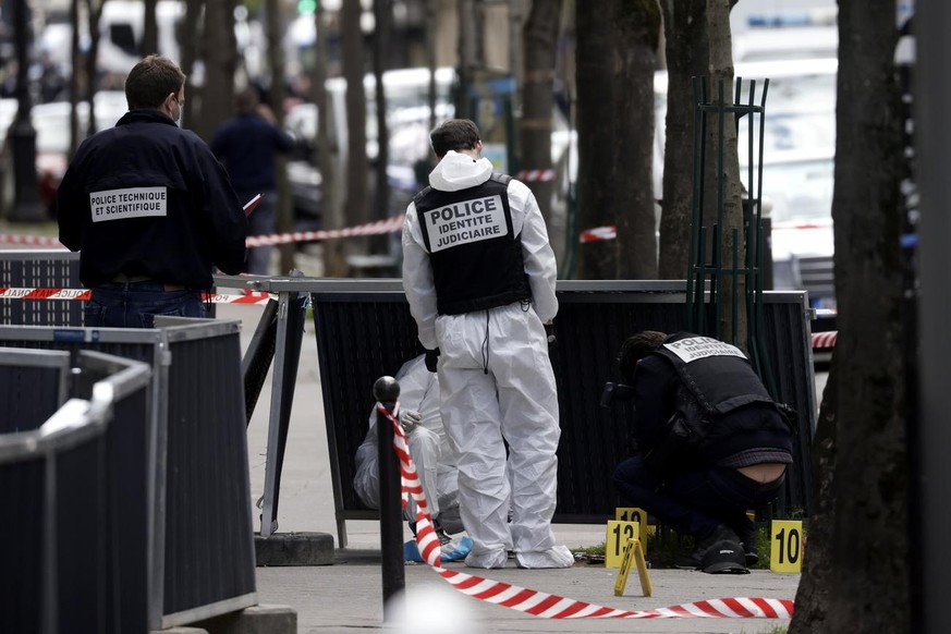 epa09130999 Forensic specialists inspect the scene of a shooting in front of the Henri Dunant hospital where two people have been shot in Paris, France, 12 April 2021. One person was shot dead, anothe ...