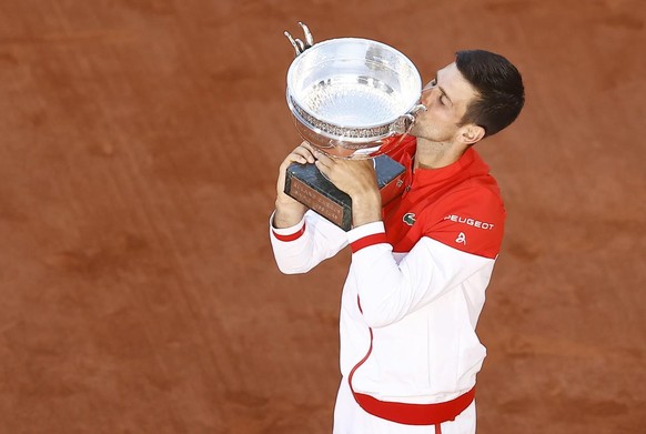 epa09268213 Novak Djokovic of Serbia celebrates with his trophy after winning against Stefanos Tsitsipas of Greece during their final match at the French Open tennis tournament at Roland Garros in Par ...