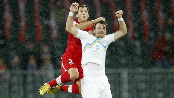 Switzerland&#039;s Reto Ziegler left, fights for the ball with Slovenia&#039;s Nejc Pecnik, right, during the FIFA World Cup 2014 group E qualifying soccer match between Switzerland and Slovenia at th ...