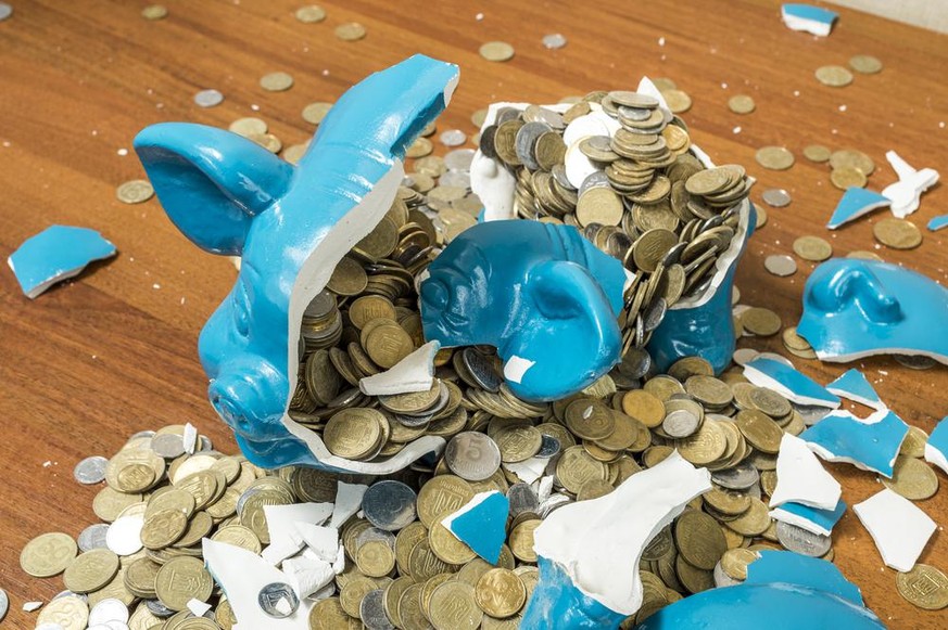 Tirelire bleue brisée en milles morceaux pièces de monnaie