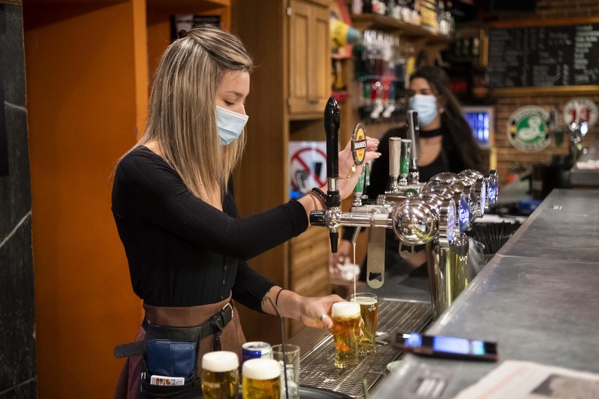 Une serveuse du &quot;Barock Cafe&quot; prepare des bieres pour des clients pendant la crise du Coronavirus (Covid-19) le mercredi 21 octobre 2020 a Martigny. En Valais, les restaurants et les bars de ...