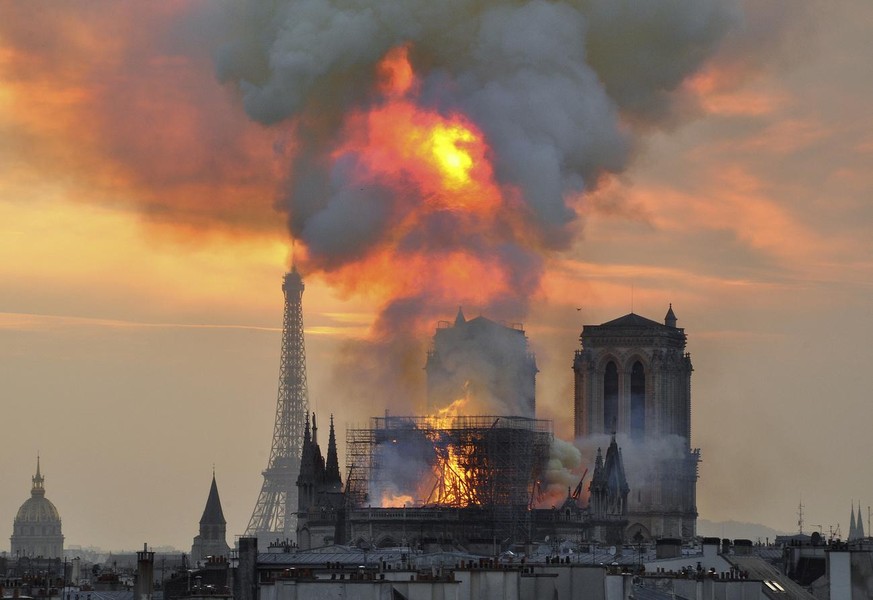 In this image made available on Tuesday April 16, 2019 flames and smoke rise from the blaze at Notre Dame cathedral in Paris, Monday, April 15, 2019. An inferno that raged through Notre Dame Cathedral ...
