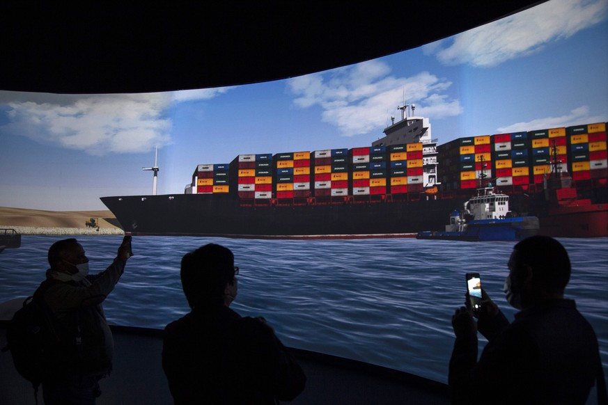 epa09104782 Reporters stand in front of a screen displaying a simulation of the pulling of Ever Given container ship in the Suez Canal, demonstrated during a press conference at the Maritime Training  ...