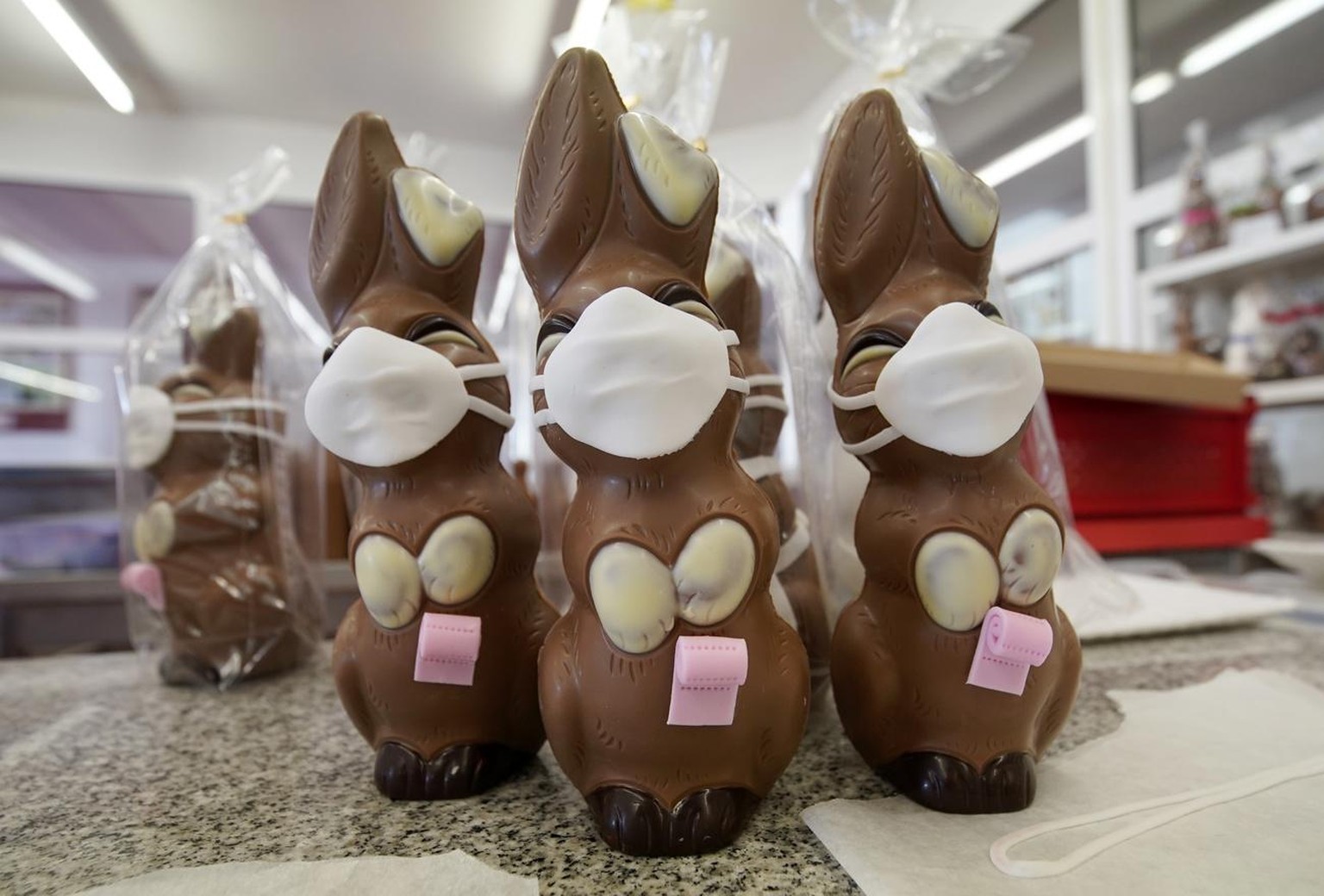 epa08350051 A view of chocolate Easter bunnies with mouth masks during the production at the Wawi company in Pirmasens, Germany, 08 April 2020. WAWI-Schokolade AG is a German company in the confection ...