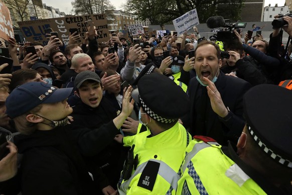 Chelsea former star goalkeeper Petr Cech, at right, behind a line of policemen, tries to calm down fans protesting outside Stamford Bridge stadium in London, against Chelsea&#039;s decision to be incl ...