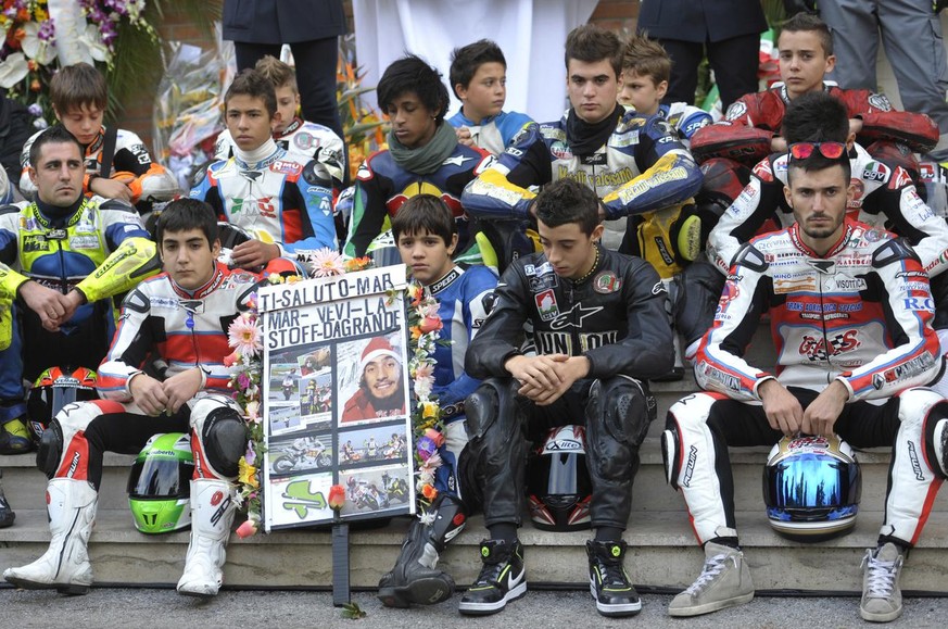 Fans of late MotoGp rider Marco Simoncelli attend the funeral service outside the Santa Maria church in Coriano, Italy, Thursday, Oct. 27, 2011. Italian sport was in shock after Marco Simoncelli died  ...