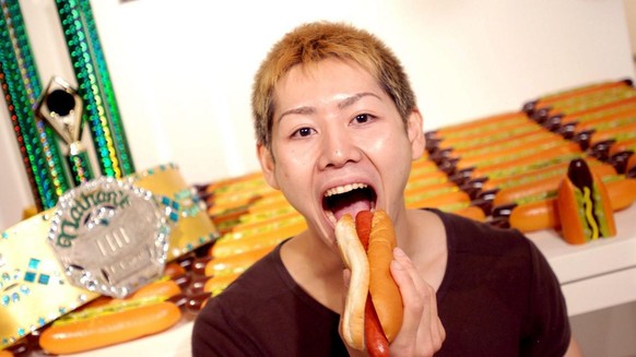 Japanese Guiness World Record holder Takeru Kobayashi, poses for the press in front of 53.5 plastic hotdogs at the Guiness World Records Museum in Tokyo, Wednesday, 3 August 2005. Kobayashi holds the  ...