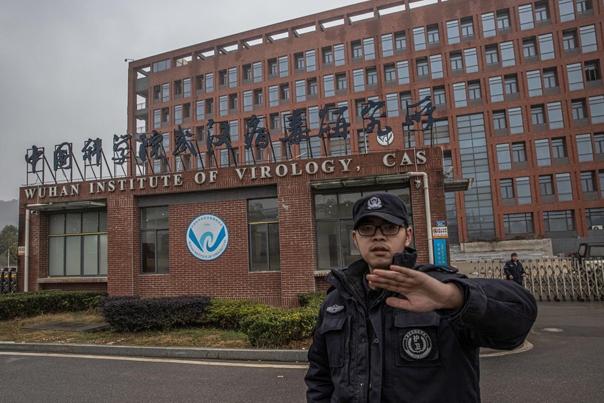 epa08968097 A security staff tries to stop the photographer from taking pictures of Wuhan Institute of Virology in Wuhan, China, 27 January 2021. The international expert team from the World Health Or ...