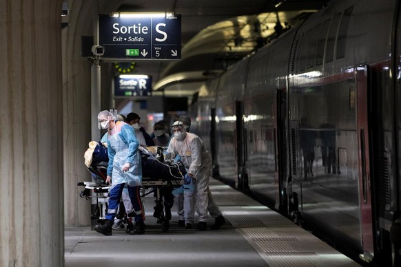 epa08337073 Medical staff carry a patient infected with the COVID-19 into a medicalised TGV high speed train at the Gare d&#039;Austerlitz train station on April 1, 2020 in Paris, France, as part of t ...