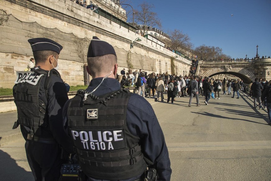 epa09056954 French Police forces evacuate the banks of the river Seine as numerous people gathered to enjoy sunbathing in Paris, France, 06 March 2021. The Police Prefecture has banned the consumption ...