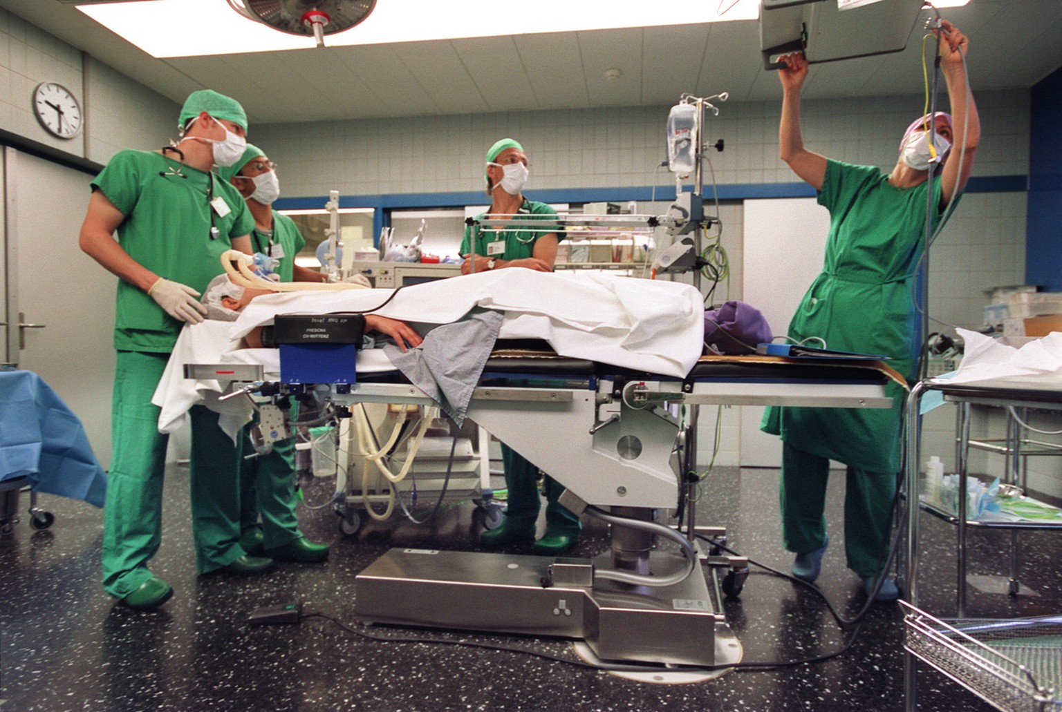 Aerzte bereiten im Operationssaal der Schaedel, Kiefer-und Gesichtschirurgie des Inselspitals Bern einen Patienten auf die Anaesthesie vor, aufgenommen am 26. Oktober 2004. (KEYSTONE/Gaetan Bally) === ...