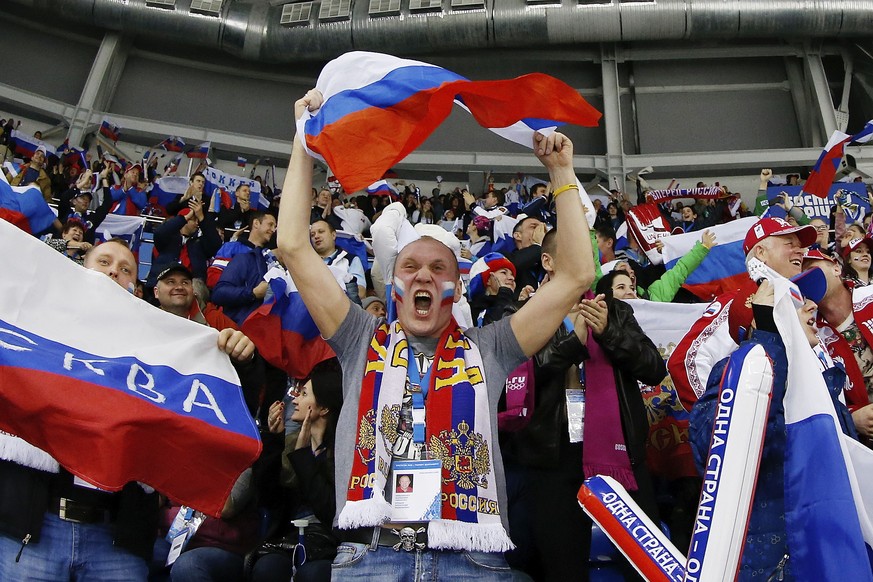 A Russian hockey fan celebrates Alyona Khomich&#039;s goal against Sweden during the 2014 Winter Olympics women&#039;s ice hockey game at Shayba Arena, Thursday, Feb. 13, 2014, in Sochi, Russia. (AP P ...