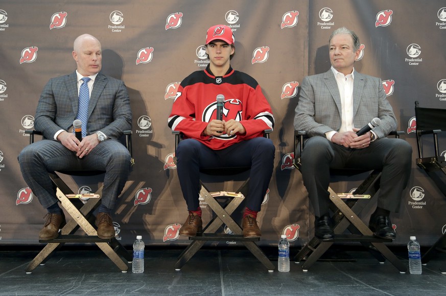 New Jersey Devils&#039; Nico Hischier, center, sits with head coach John Hynes, left, and general manager Ray Shero during a news conference in Newark, N.J., Monday, June 26, 2017. The 18-year-old cen ...