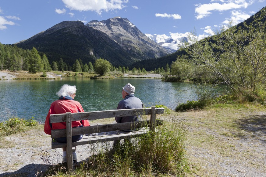 An elderly couple sitting on a bench at a lake near &quot;Morteratsch&quot; above the village of Pontresina in the canton of Grisons&#039; Upper Engadine Valley, Switzerland, pictured on August 16, 20 ...