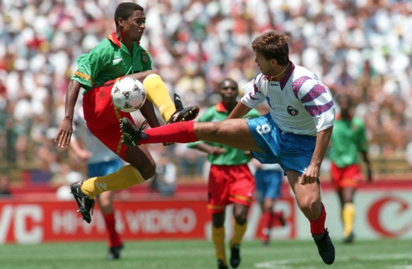 28 JUN 1994: OLEG SALENKO OF RUSSIA CHARGES IN ON HANS AGBO OF CAMEROON DURING THEIR 1994 WORLD CUP MATCH AT THE STANFORD STADIUM IN PALO ALTO, CALIFORNIA. Mandatory Credit: Stephen Dunn/ALLSPORT