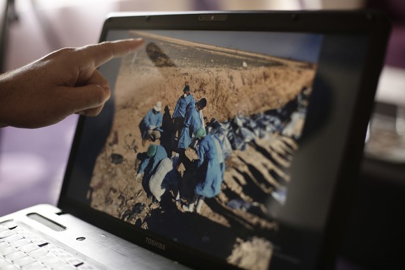 FILE - In this May 17, 2016, file, photo, Sirwan Jalal, Director of Mass Graves for the Kurdish Regional Government, points to an image of the site of a mass grave during an interview with the Associa ...