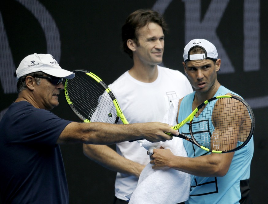 Spain&#039;s Rafael Nadal, right, talks with his uncle Toni Nadal, left, as coach Carlos Moya looks on during a practice session ahead of the Australian Open tennis championships in Melbourne, Austral ...