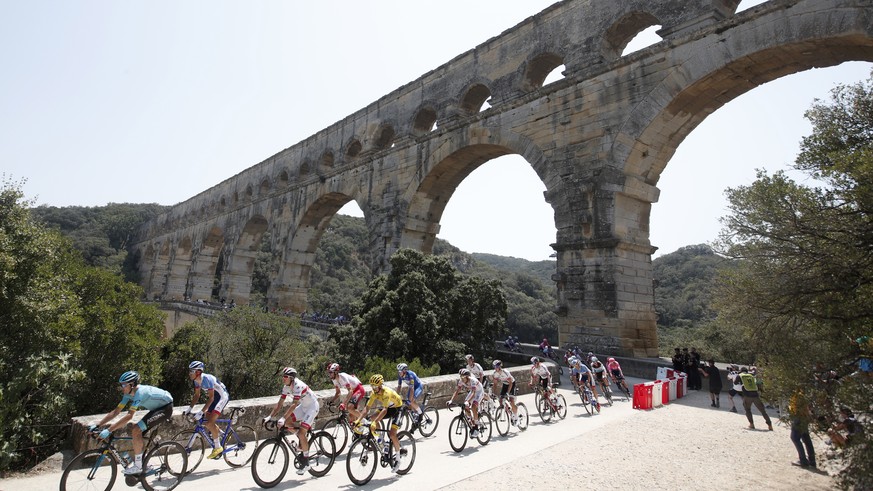epa07735350 The pack rides over the Pont du Gard bridge during the 16th stage of the 106th edition of the Tour de France cycling race over 177km around Nimes, France, 23 July 2019. EPA/GUILLAUME HORCA ...