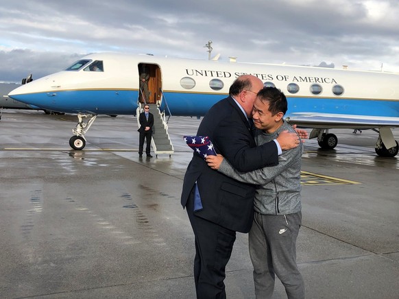 This photo provided by U.S. Embassy Switzerland, Edward McMullen greets Xiyue Wang in Zurich, Switzerland on Saturday, Dec. 7, 2019. In a trade conducted in Zurich, Iranian officials handed over Chine ...