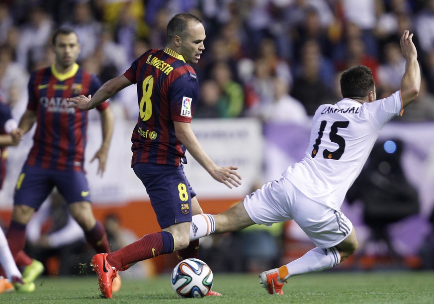 Real&#039;s Daniel Carvajal, right, falls in front of Barcelona&#039;s Andres Iniesta during the final of the Copa del Rey between FC Barcelona and Real Madrid at the Mestalla stadium in Valencia, Spa ...