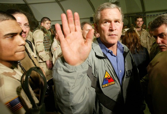 U.S. President George W. Bush reacts while explaining to member s of the media that he will not answer questions at Baghdad International Airport, Thursday, 27 November 2003. United States President G ...