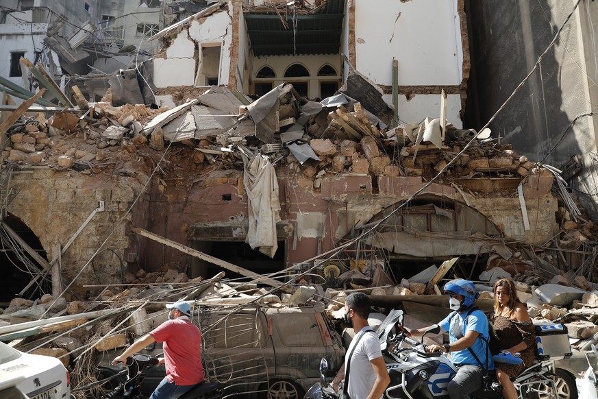 Citizens ride their scooters and motorcycles pass in front of a house that was destroyed in Tuesday&#039;s massive explosion in the seaport of Beirut, Lebanon, Wednesday, Aug. 5, 2020. Residents of Be ...