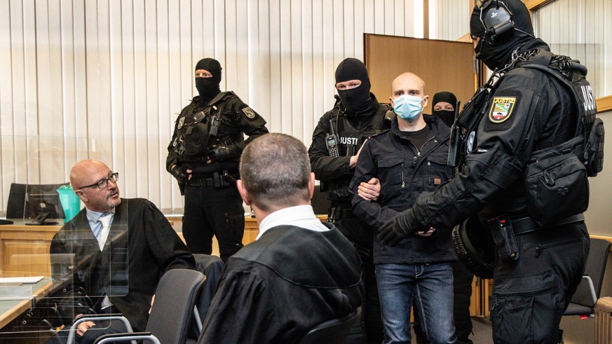 epaselect epa08558220 Defendant Stephan Balliet (3-R) arrives for the main trial of the terror attack in Halle next to his lawyers Hans-Dieter Weber (L) and Thomas Rutkowski (3-L) at regional court in ...