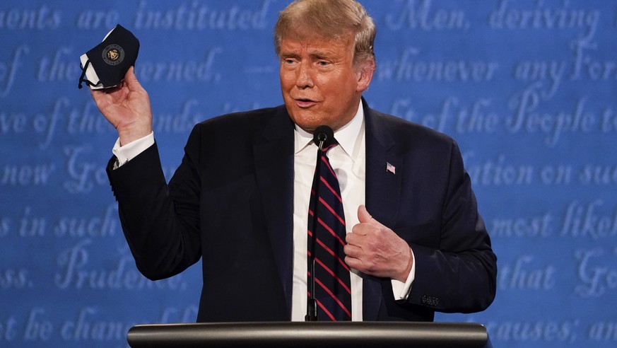 In this Sept. 29, 2020, file photo, President Donald Trump holds up his face mask during the first presidential debate at Case Western University and Cleveland Clinic, in Cleveland, Ohio. President Tr ...