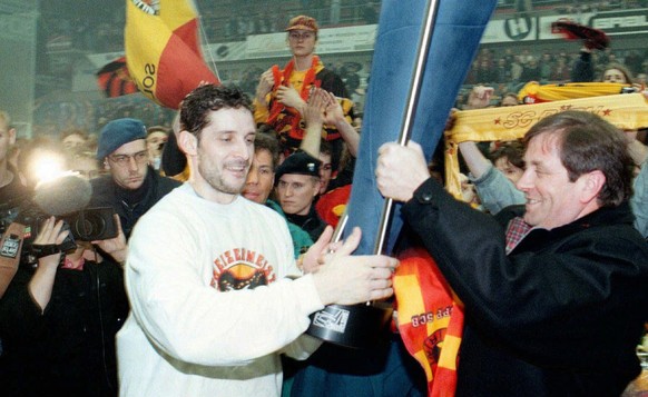 Der Captain des SC Bern, Roberto Triulzi (links) holt sich am Donnerstag 27.3.1997 den Pokal von Praesident Zoelch (rechts) in Zug. (Keystone/Tischler/Limina)