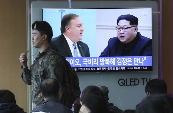 A South Korean army soldier passes by a TV screen showing file footage of CIA Director Mike Pompeo, left, and North Korean leader Kim Jong Un during a news program at the Seoul Railway Station in Seou ...
