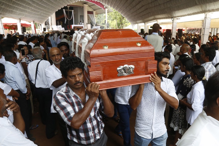 epaselect epa07522313 The coffin with the body of a victim of a series of bomb blasts arrives for a mass funeral at the Katuwapitiya Church in Colombo, Sri Lanka 23 April 2019. According to police rep ...
