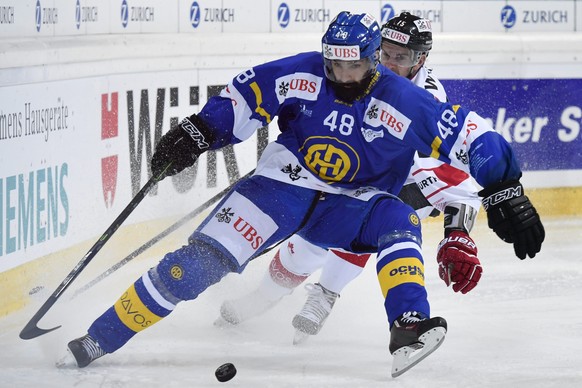epa05689609 Davos&#039; Daniel Rahimi (L) fights for the puck with Team Canada&#039;s Dustin Jeffrey during the game between Switzerlands HC Davos and Team Canada at the 90th Spengler Cup ice hockey t ...