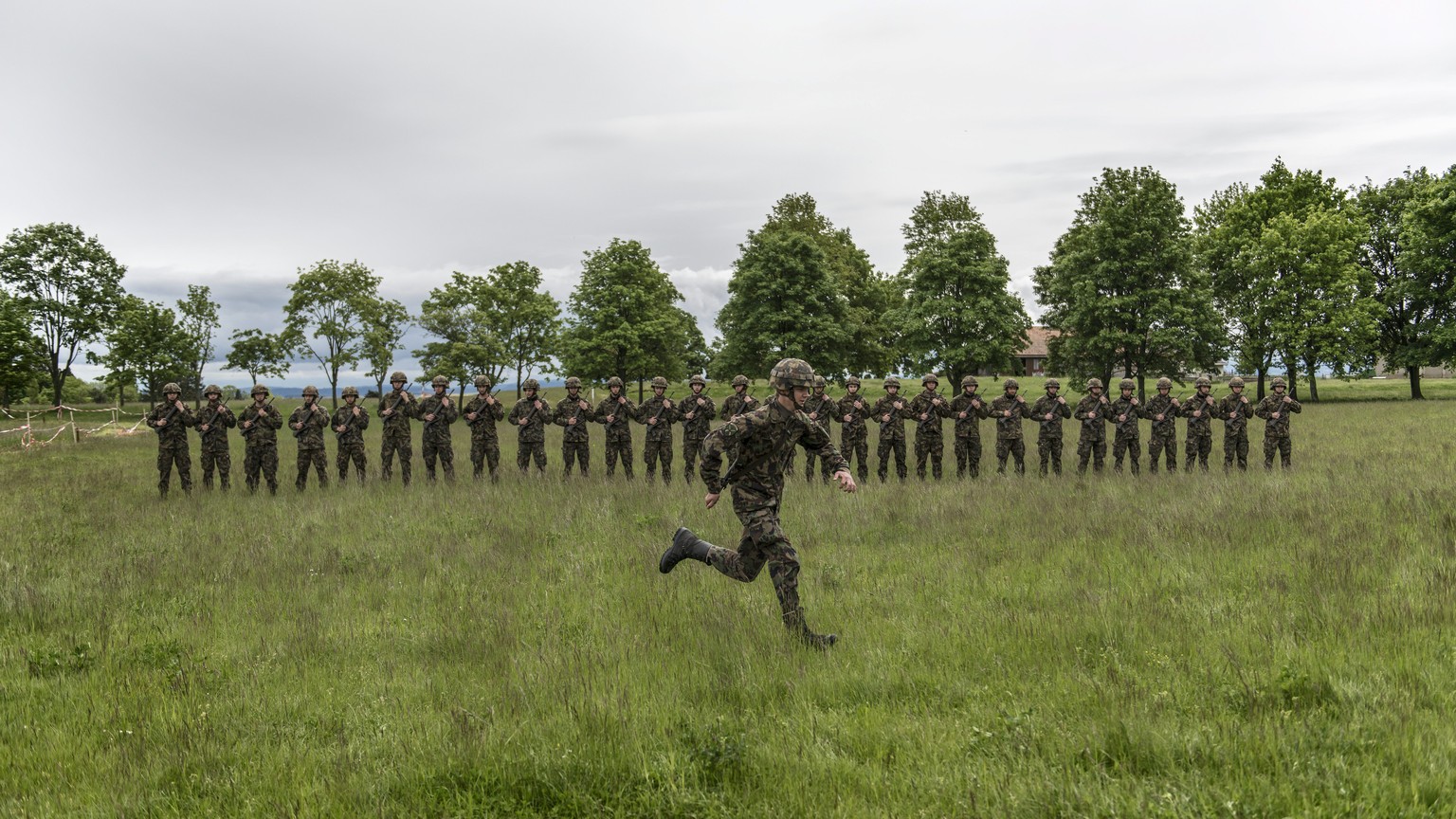JAHRESRUECKBLICK 2013 - MAI - Rekruten der Infanterie stehen auf der gruenen Wiese in Reih und Glied, waehrend ein weiterer Rekrut vorbeisprintet, aufgenommen am 17. Mai in der Infanterie RS 5 (Rekrut ...