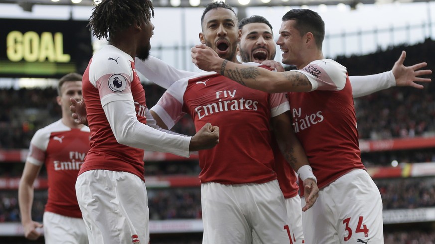 Arsenal&#039;s Pierre-Emerick Aubameyang, center, celebrates with his teammates after scoring his side&#039;s opening goal from a penalty spot during the English Premier League soccer match between Ar ...