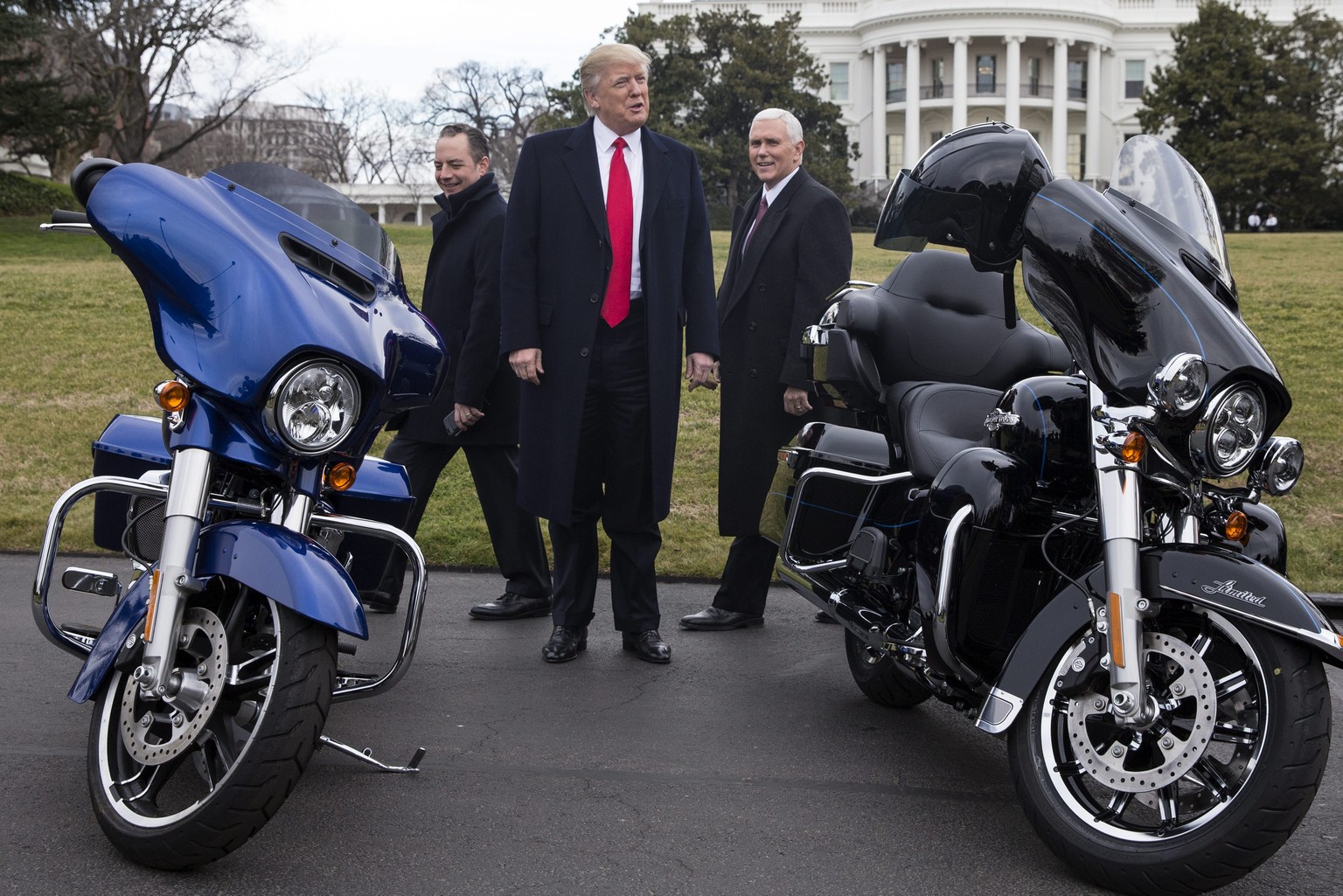 epa05767240 US President Donald J. Trump (C), US Vice President Mike Pence (R) and White House Chief of Staff Reince Priebus (L) look at Harley Davidson motorcycles while greeting Harley Davidson exec ...