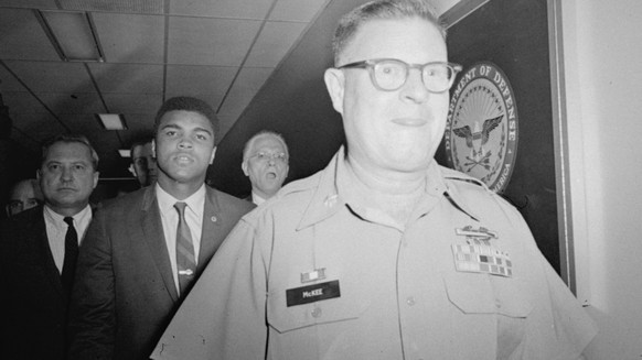 FOR USE IN CENTURY-END EDITIONS--FILE--Heavyweight champion Muhammad Ali is pictured being escorted from the Armed Forces Examining and Entrance Station in Houston, Texas, April 28, 1967, by Lt. Col.  ...