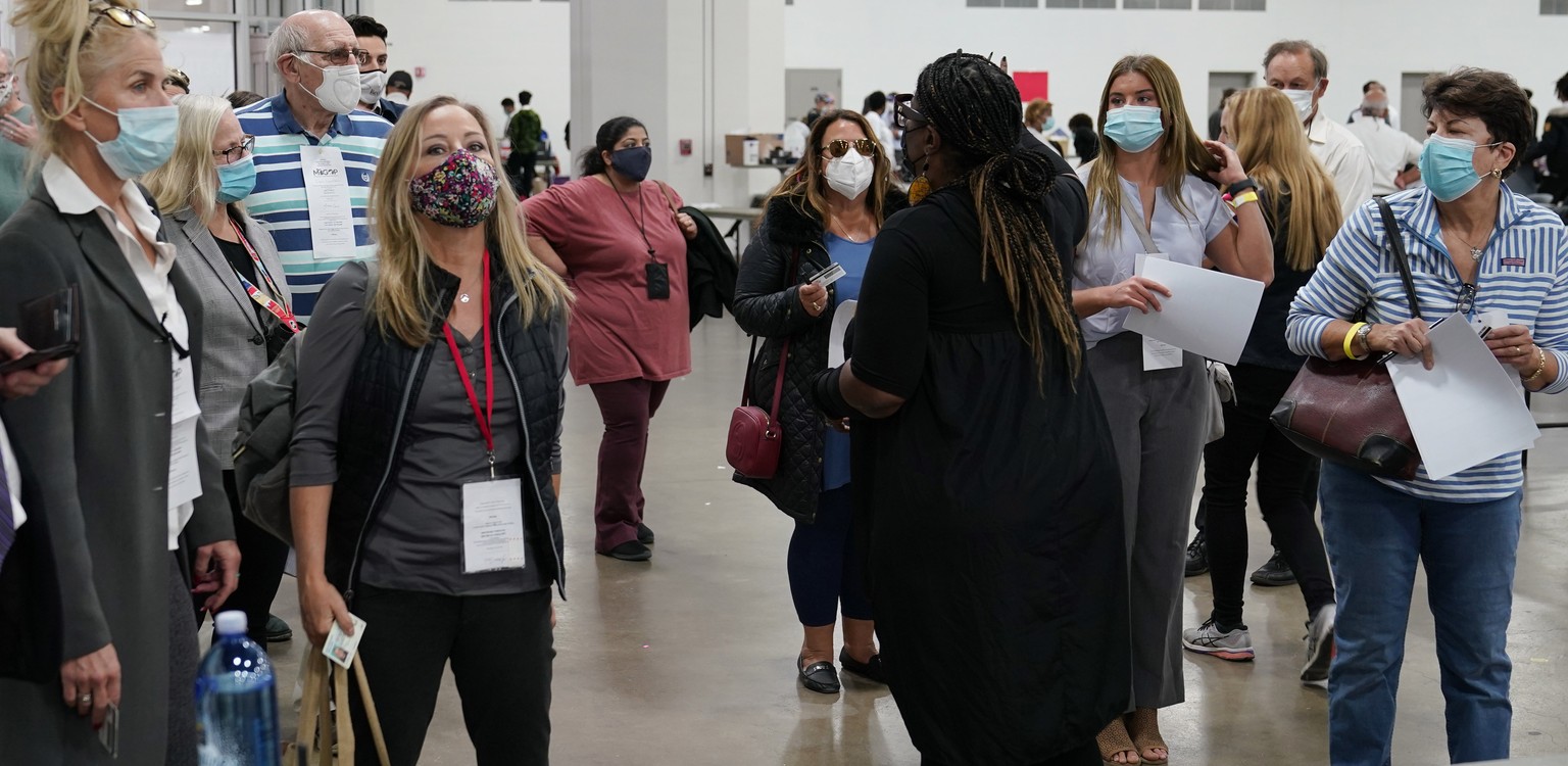 Challengers are instructed as they check in to observe absentee ballots being processed at the central counting board, Wednesday, Nov. 4, 2020, in Detroit. With the outcome of the U.S. presidential ra ...