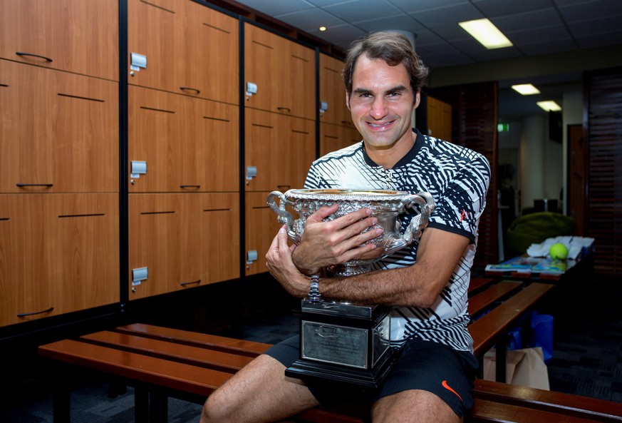Switzerland&#039;s Roger Federer hugs the trophy after winning the Men&#039;s singles final at the Australian Open tennis tournament in Melbourne, Australia in this handout image taken January 30, 201 ...