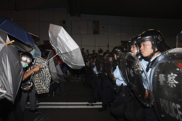 Demonstranten der Umbrella-Revolution und Polizisten stehen sich gegenüber.