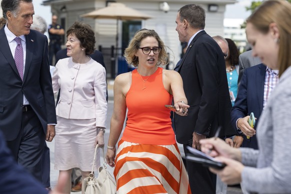 epa09299224 Republican Senator from Utah Mitt Romney (L), Republican Senator from Maine Susan Collins (C-L), and Democratic Senator from Arizona Kyrsten Sinema (C) join other senators from the group o ...