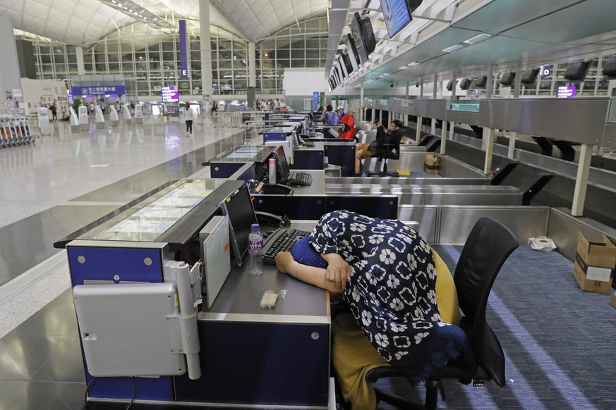 Stranded travelers sleep at the check-in counters at the Hong Kong International Airport, Monday, Aug. 12, 2019. One of the world&#039;s busiest airports canceled all flights after thousands of Hong K ...