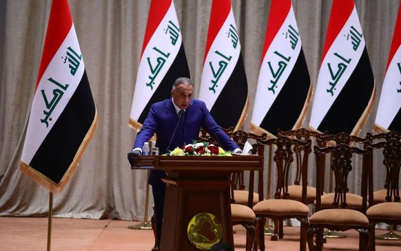 epa08406426 A handout photo made available by the Iraqi Prime Minister Office shows Newly-elected Iraqi Prime Minister Mustafa al-Kadhimi delivering a speech at the Iraqi parliament headquarters in Ba ...